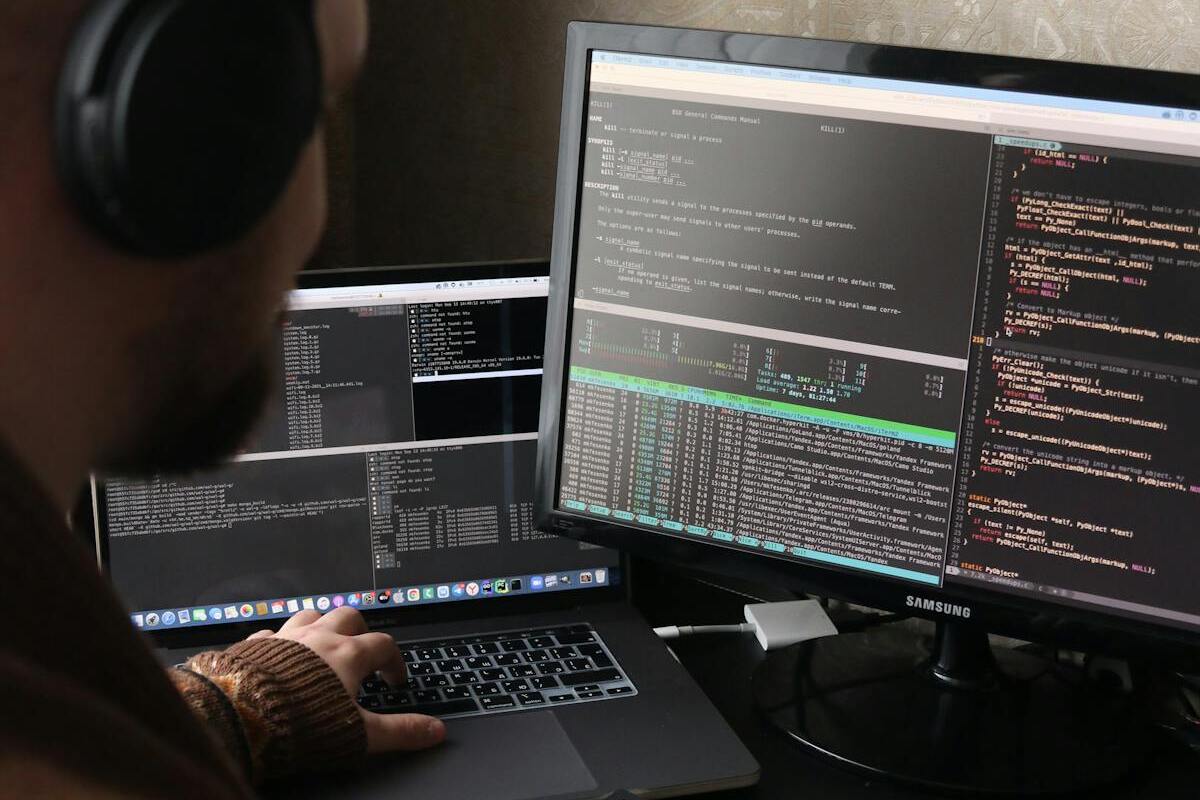 Developer working on multiple screens — digital nomad freelancer coding setup