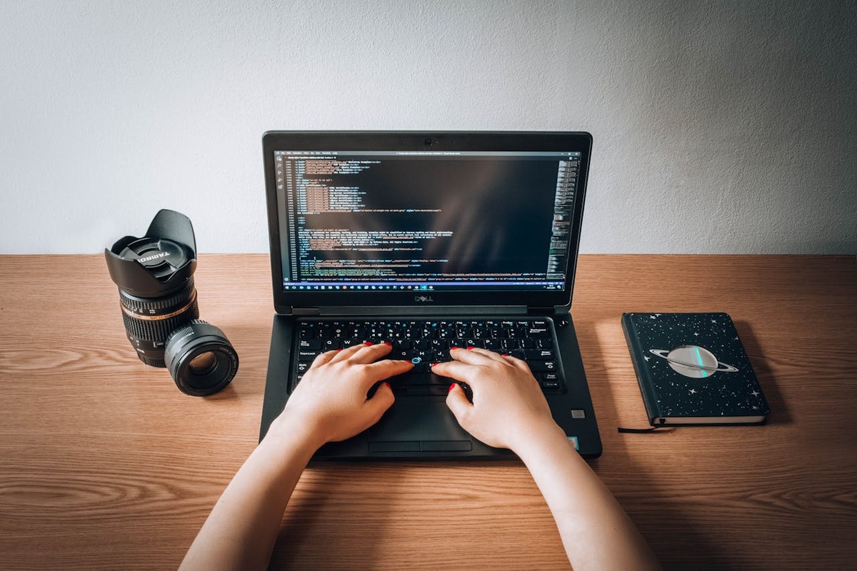 Programmer working at minimal wooden desk home office - remote AI solopreneur workspace