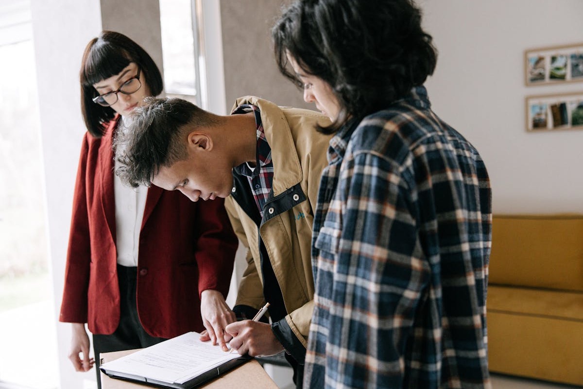 Couple signing real estate purchase documents with a real estate agent at closing