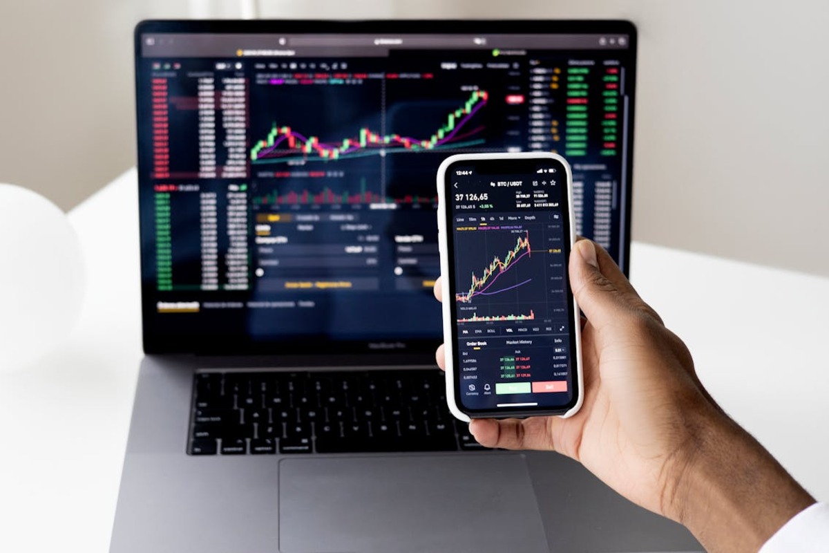 Investor reviewing stock market charts on phone - capital gains tax planning for US expats
