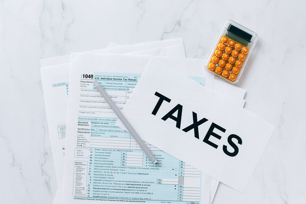Tax forms and calculator on table representing expat rental property reporting requirements