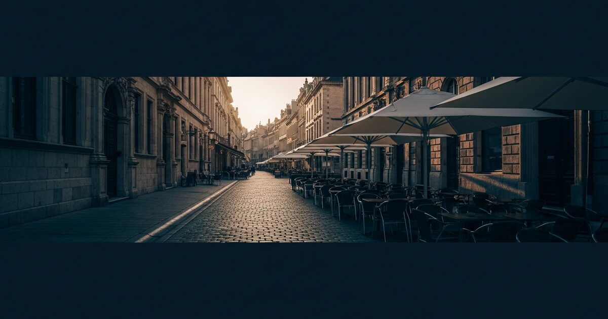 cobblestone pedestrian street in a European old city center with outdoor café seating at morning