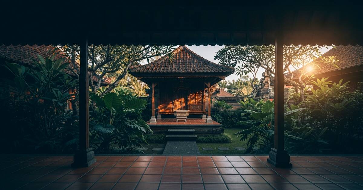 Sunlit traditional Indonesian wooden pavilion with terracotta tiles and lush tropical garden