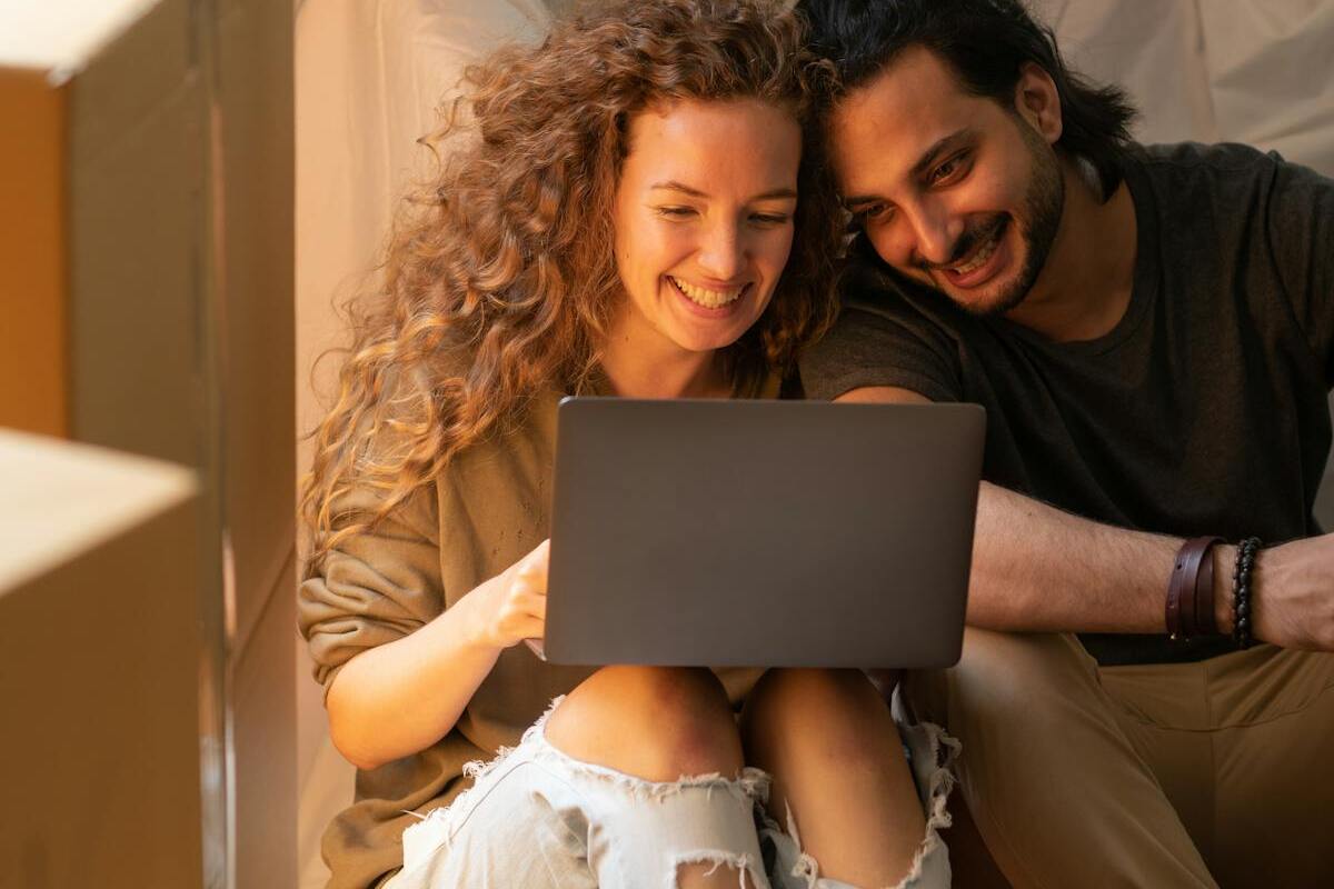 Expat couple using laptop to manage their short-term rental property abroad