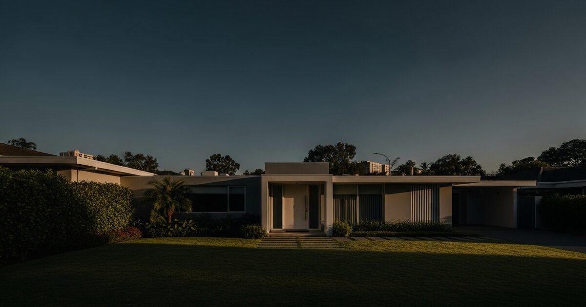 Modern residential home exterior with green lawn and minimalist front door in warm afternoon light