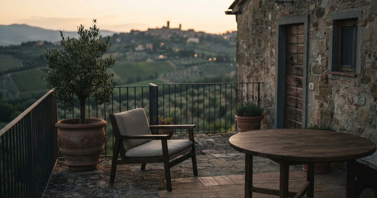 Hillside stone apartment terrace at golden hour with empty table