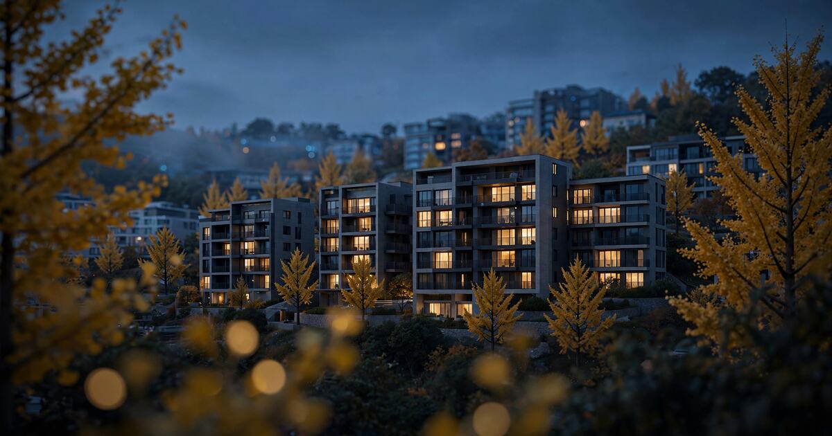 Quiet hillside apartments with warm windows among autumn ginkgo trees at dusk