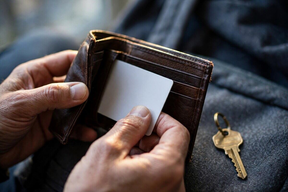 Hands placing a blank residence card into a leather travel wallet