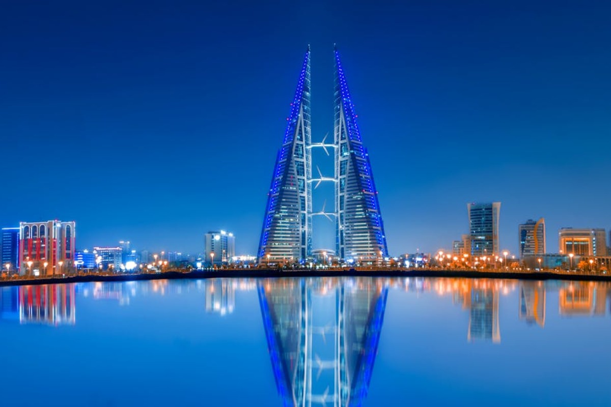 Bahrain World Trade Center illuminated at dusk over Manama skyline